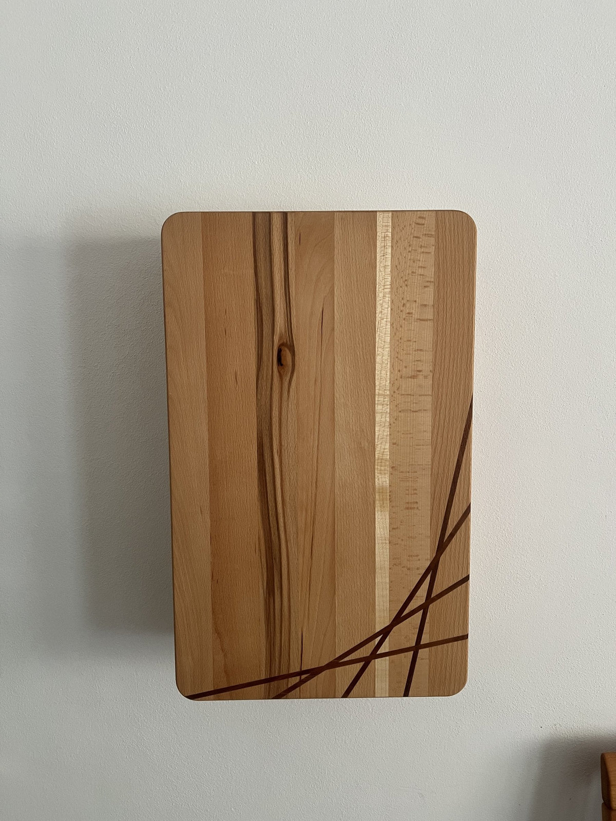 Schmuckschrank aus Kernbuche mit Mahagoni-Einleimern an der Wand