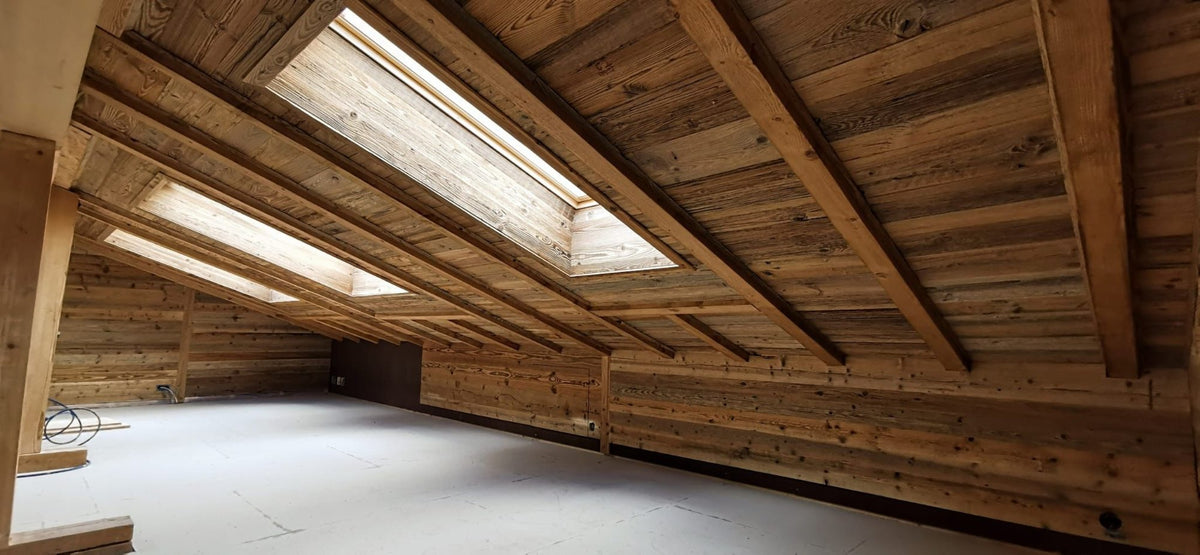 Renoviertes Dachgeschoss einer Ferienwohnung in Flims mit Holzverkleidung und Dachfenstern